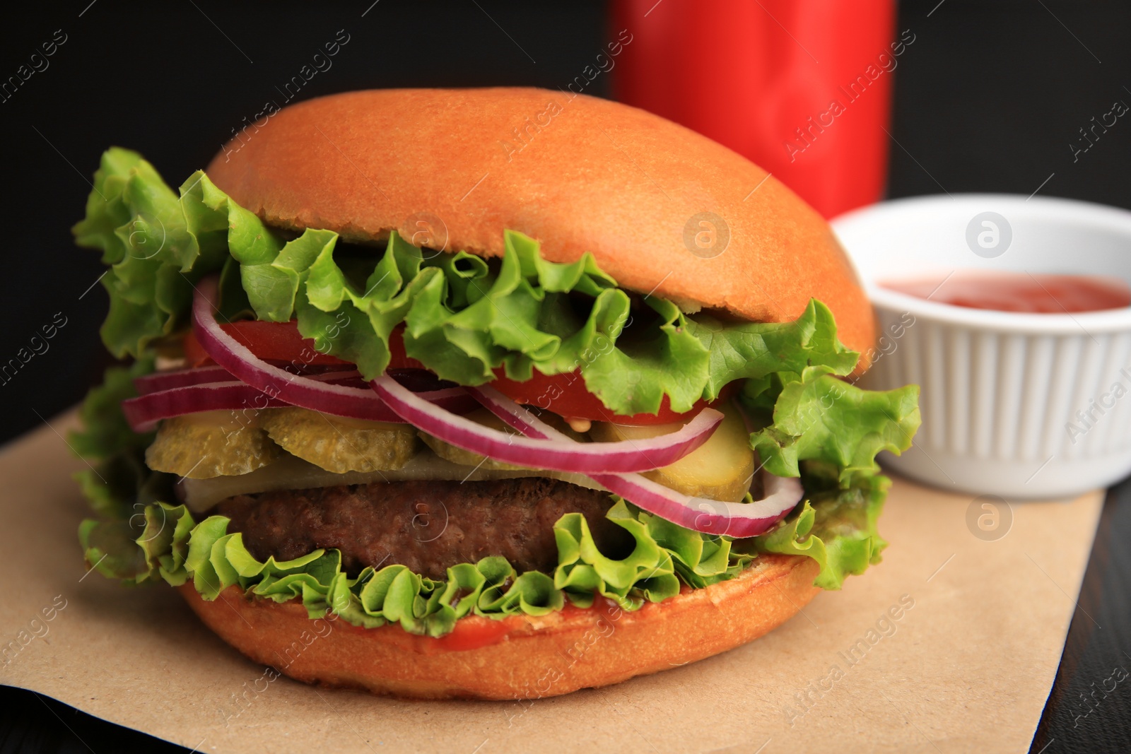 Photo of One tasty burger with vegetables, patty and lettuce on table, closeup