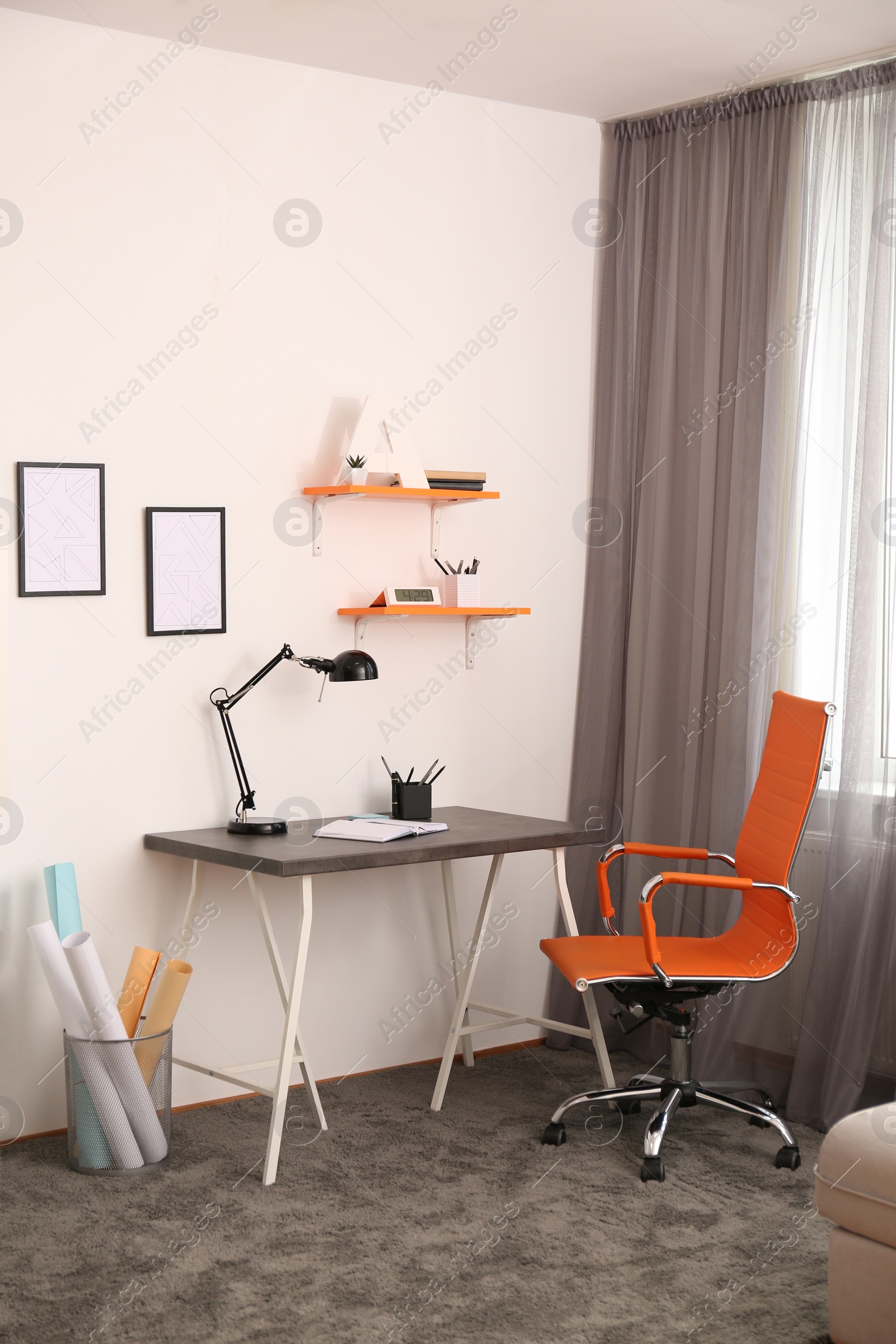 Photo of Stylish room interior with comfortable workplace near window. Design idea