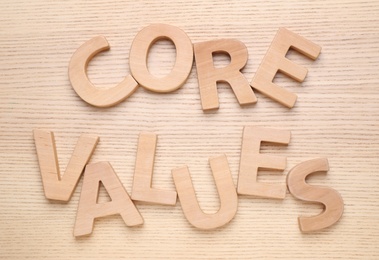 Photo of Phrase CORE VALUES made of letters on wooden background, flat lay