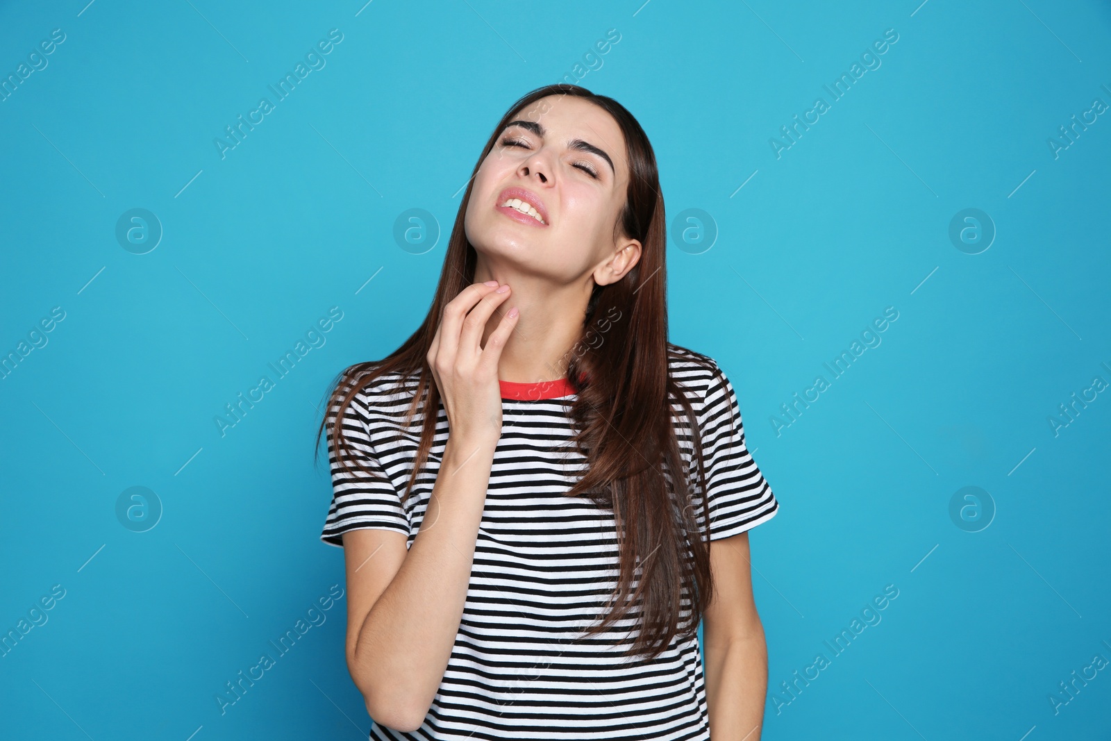 Photo of Young woman scratching neck on color background. Annoying itch