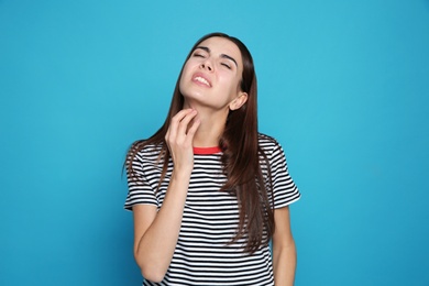 Photo of Young woman scratching neck on color background. Annoying itch