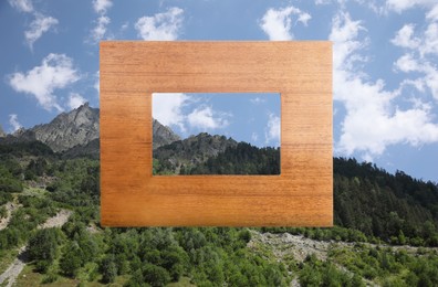 Image of Wooden frame and beautiful mountains under blue sky with clouds