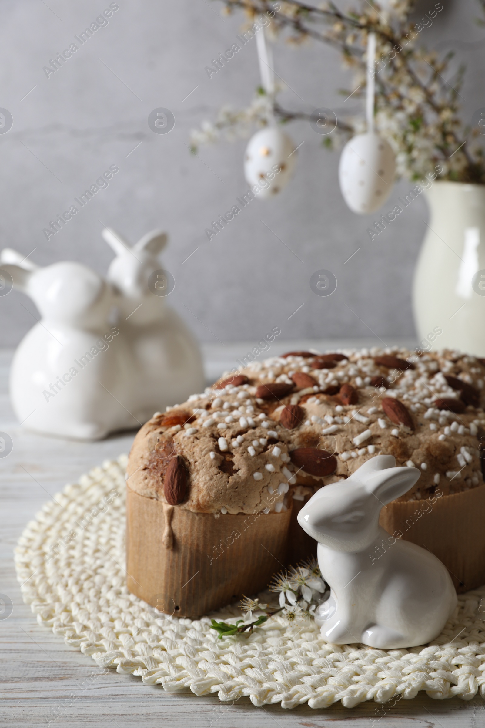 Photo of Delicious Italian Easter dove cake (Colomba di Pasqua) and festive decor on white wooden table