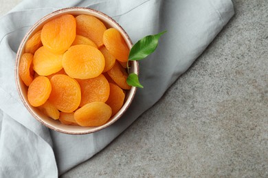 Bowl of tasty apricots and space for text on grey table, top view. Dried fruits