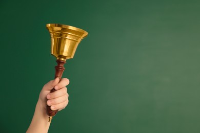 Pupil with school bell near chalkboard, closeup. Space for text