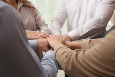 Photo of Group of people holding their hands together, closeup