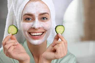 Woman with face mask and cucumber slices on blurred background, closeup and space for text. Spa treatments