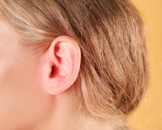 Image of Woman suffering from earache on color background, closeup 