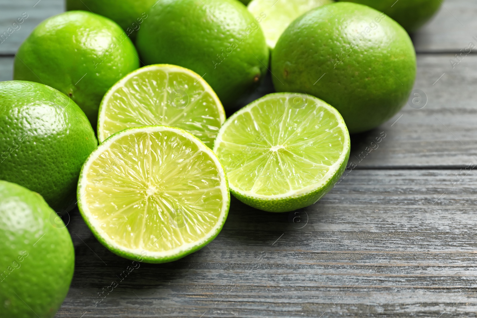 Photo of Fresh ripe limes on wooden table. Citrus fruit