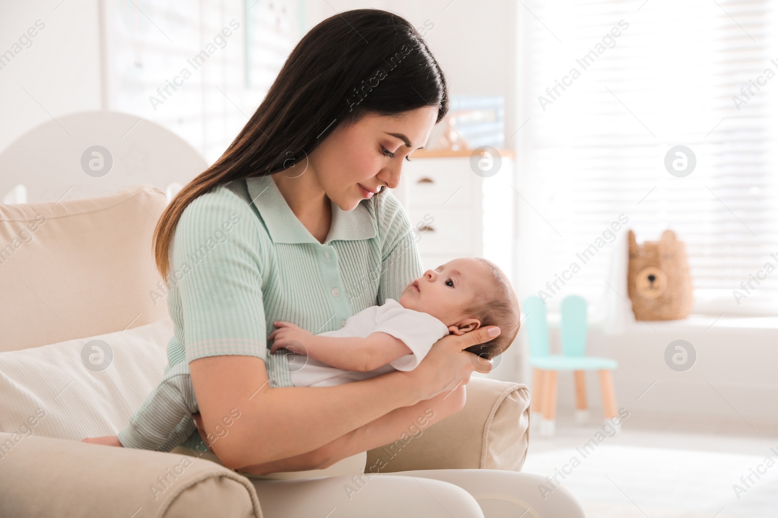 Photo of Young woman with her cute baby at home