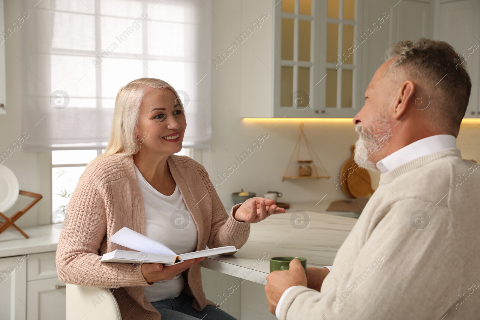 Photo of Happy senior couple spending time together in kitchen