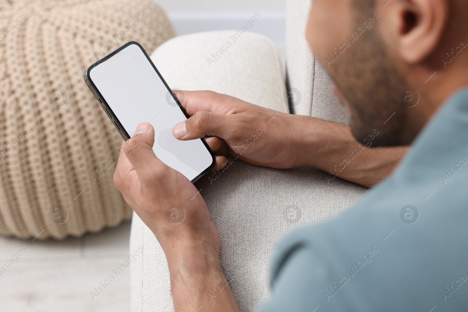 Photo of Man using modern mobile phone indoors, selective focus