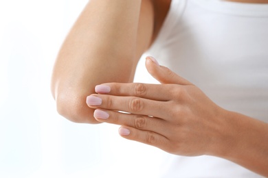 Photo of Young woman applying cream on white background, closeup. Beauty and body care