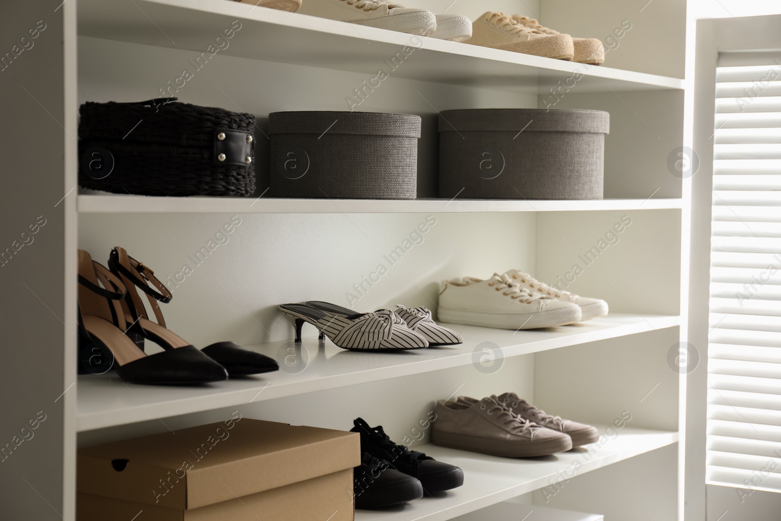 Photo of Storage rack with stylish women's shoes indoors