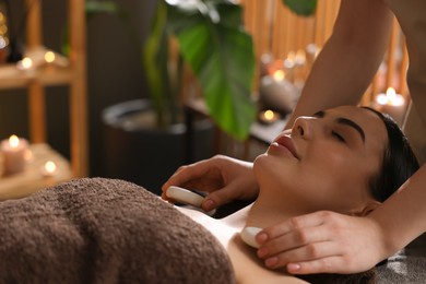 Photo of Spa therapy. Beautiful young woman lying on table during massage in salon