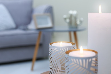 Photo of Burning candles indoors, closeup. Interior decor element