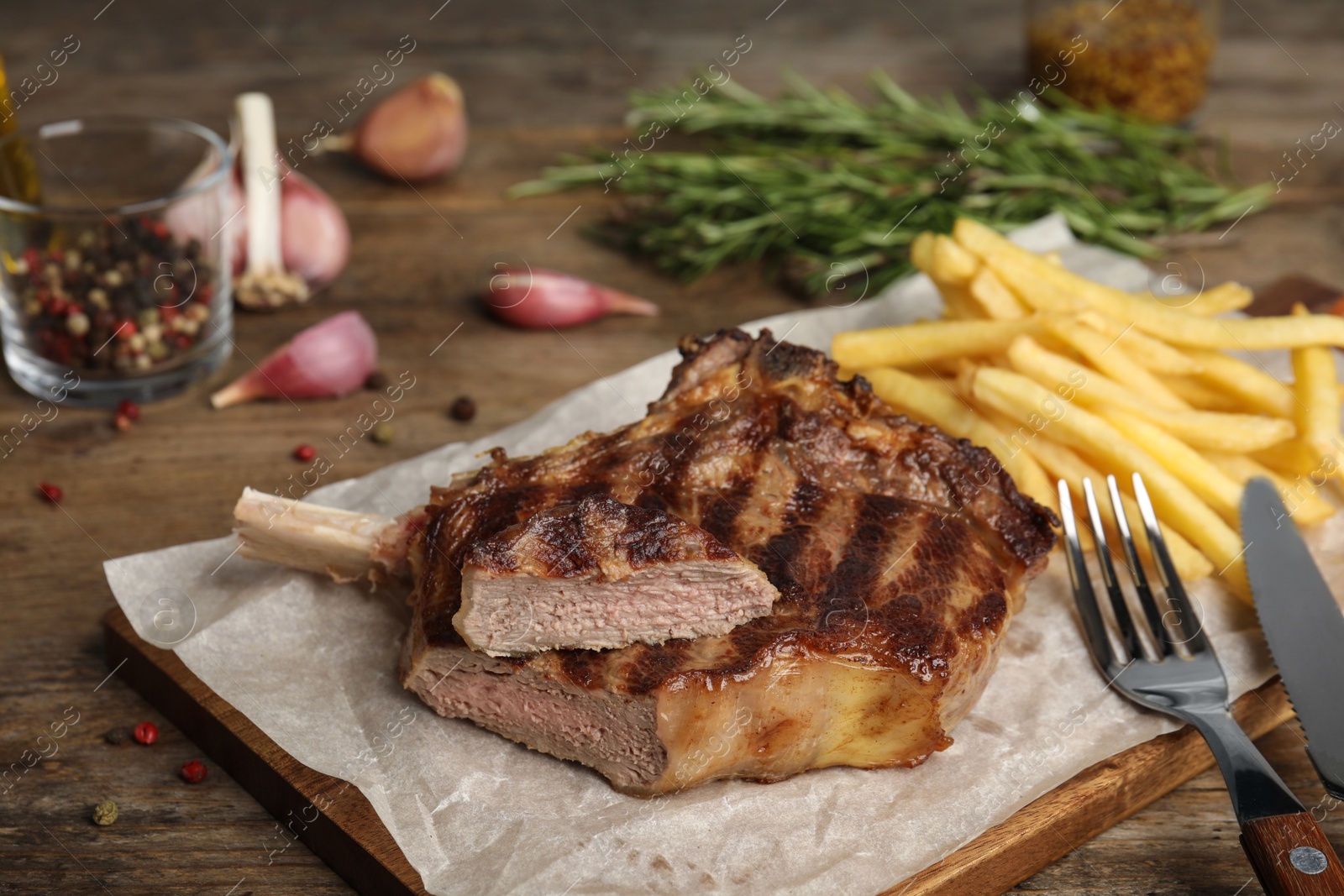 Photo of Tasty grilled beef steak and French fries on wooden table