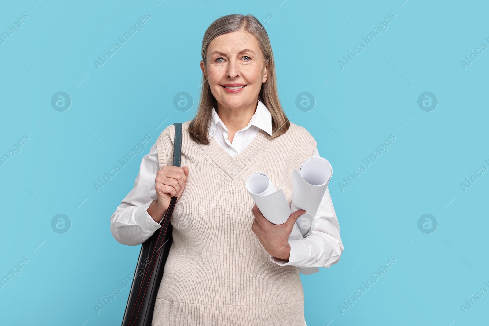 Photo of Architect with drafts and tube on light blue background