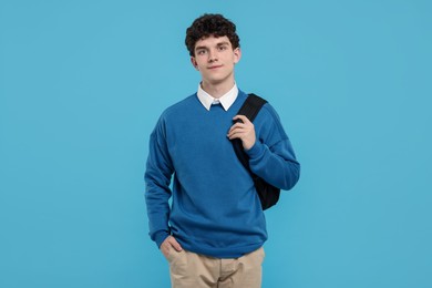Photo of Portrait of student with backpack on light blue background