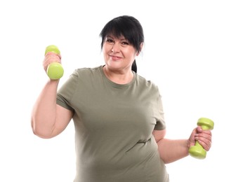 Happy overweight mature woman doing exercise with dumbbells on white background