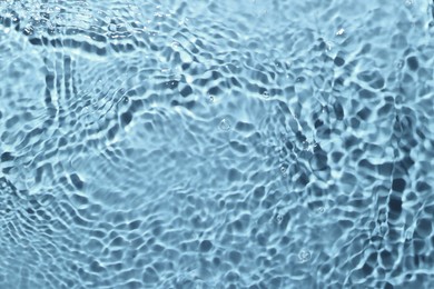 Image of Rippled surface of clear water on light blue background, top view