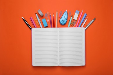 Photo of Flat lay composition with open notebook and other school stationery on red background, space for text. Back to school