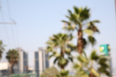 Photo of San Pedro Garza Garcia, Mexico – March 20, 2023: Blurred view of city with buildings and green palms