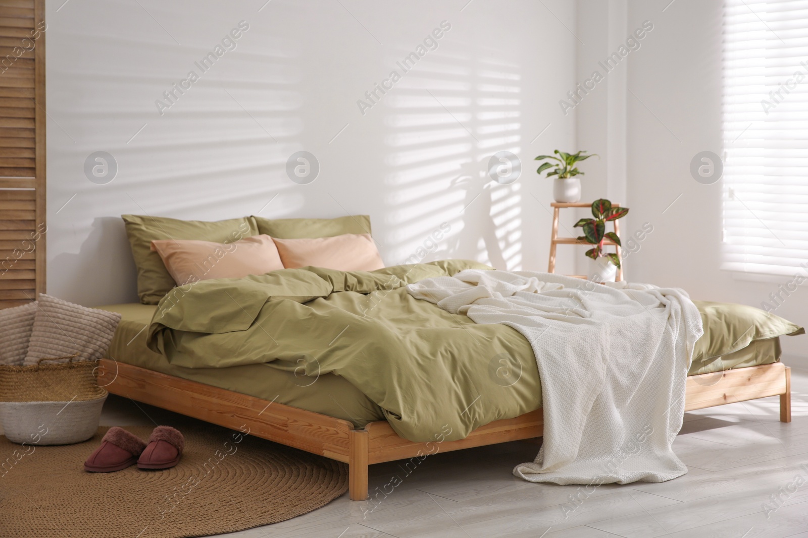 Photo of Large bed with soft blanket in stylish room interior