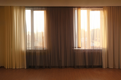 Photo of Windows with beautiful curtains in empty room