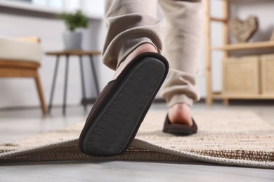 Photo of Man tripping over rug at home, closeup