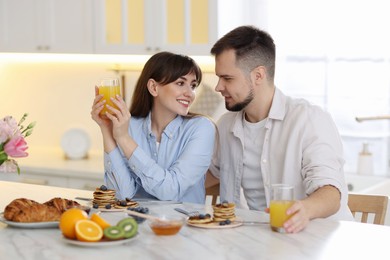 Happy couple having tasty breakfast at home