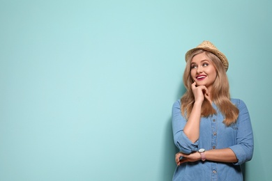 Attractive young woman in stylish outfit on color background