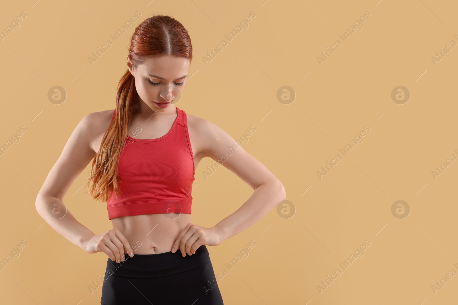 Photo of Young woman in sportswear on beige background, space for text