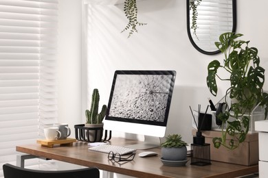 Photo of Cozy workspace with computer on wooden desk at home