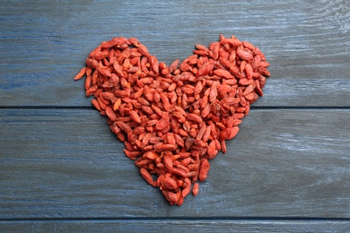 Heart made of dried goji berries on wooden table, top view. Healthy superfood