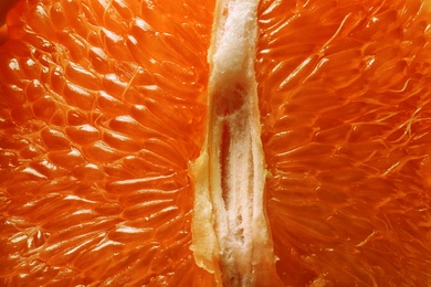 Peeled ripe grapefruit as background, closeup. Orange citrus fruit