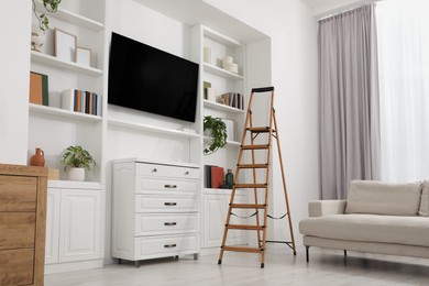 Wooden folding ladder in stylish living room