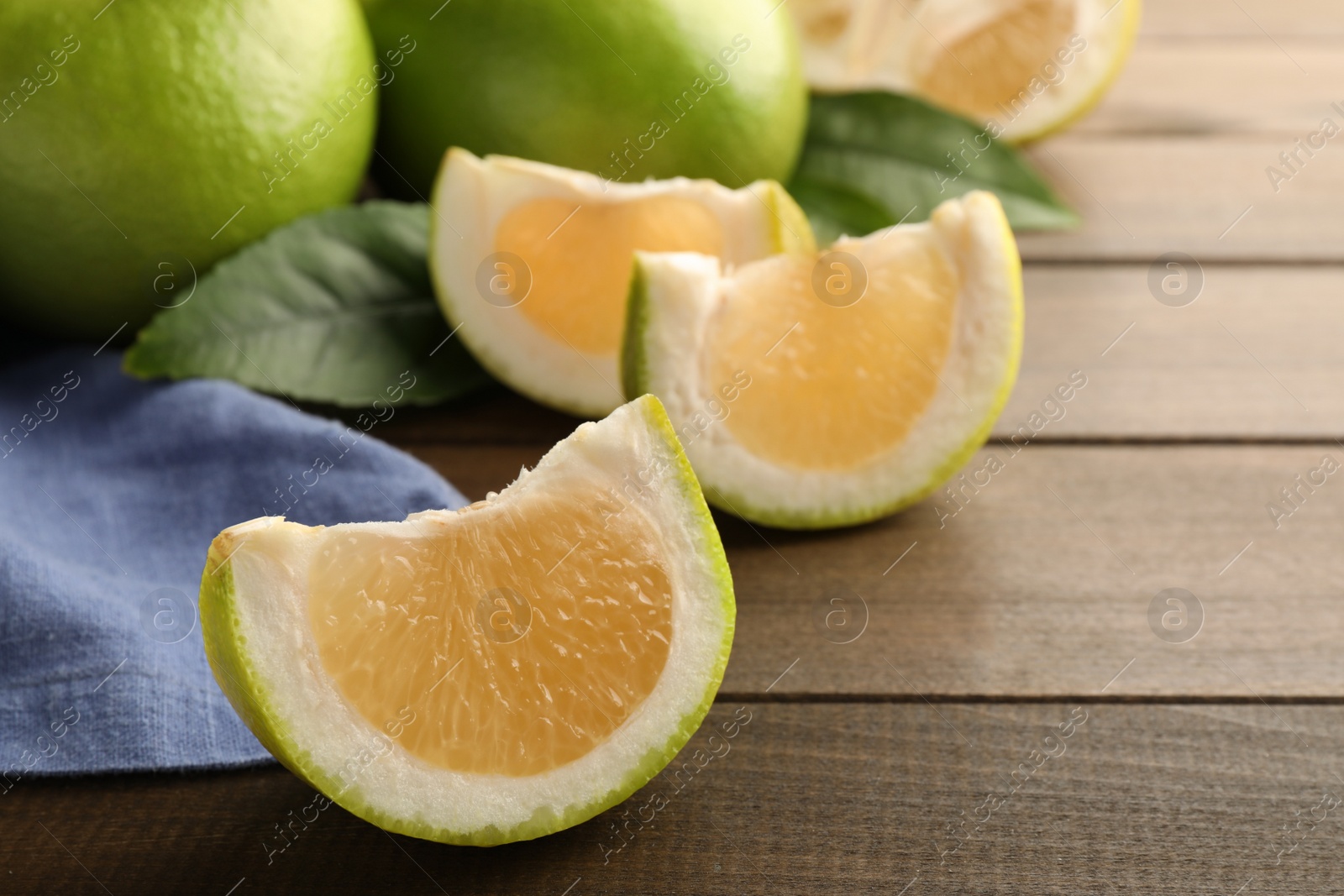 Photo of Sliced sweetie fruit on wooden table, space for text