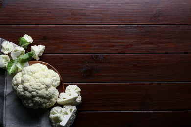 Photo of Plate with fresh raw cauliflower on wooden table, flat lay. Space for text