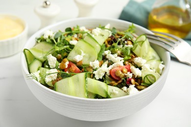 Delicious salad with lentils, vegetables and feta cheese served on white table, closeup