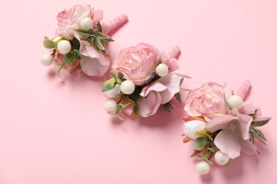 Stylish boutonnieres on pink background, above view