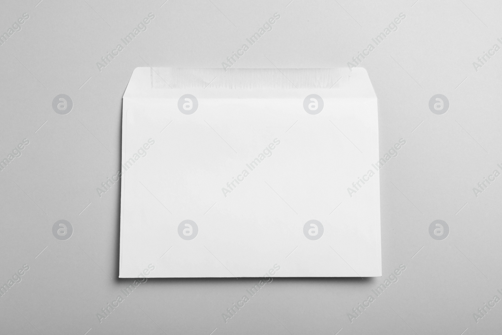 Photo of White paper envelope on light grey background, top view