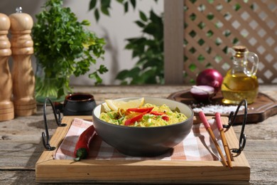 Photo of Stir-fry. Tasty noodles with vegetables and meat in bowl served on wooden table