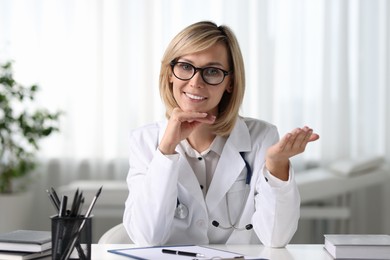 Portrait of smiling doctor at table in office