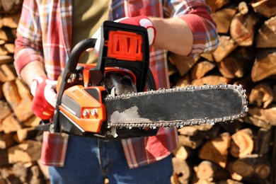 Man with modern saw on sunny day, closeup