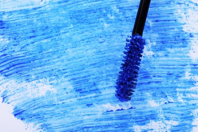Photo of Applicator brush with blue mascara, closeup. Space for text