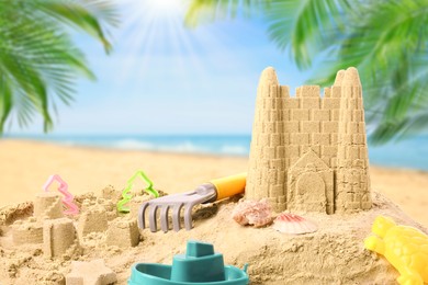 Sand castle with toys on ocean beach. Outdoor play