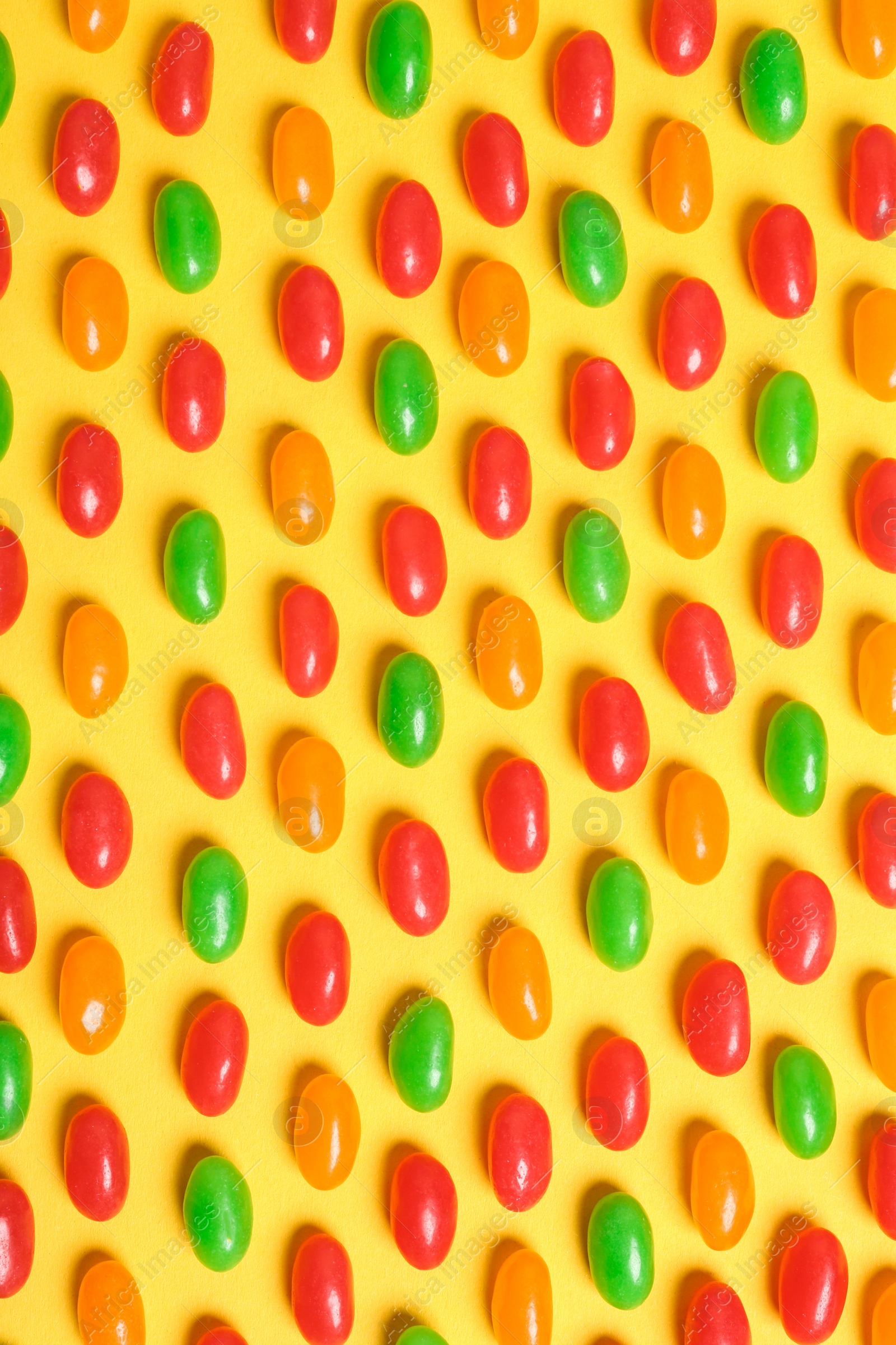 Photo of Flat lay composition with delicious jelly beans on color background