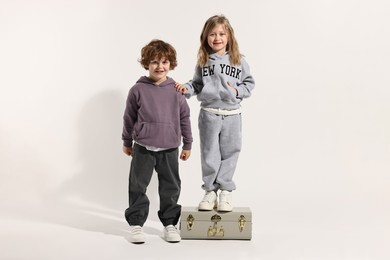 Fashion concept. Stylish children with vintage suitcase on white background