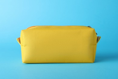 Yellow cosmetic bag on light blue background